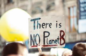 Bord met de tekst 'there is no planet B' dat omhoog wordt gehouden tijdens een demonstratie